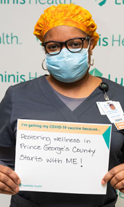 Lakeesha Colbert with a sign for her reason to get the COVID-19 vaccine