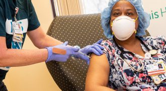 Tywana Jackson, respiratory therapist at Luminis Health Anne Arundel Medical Center, gets the COVID-19 vaccine