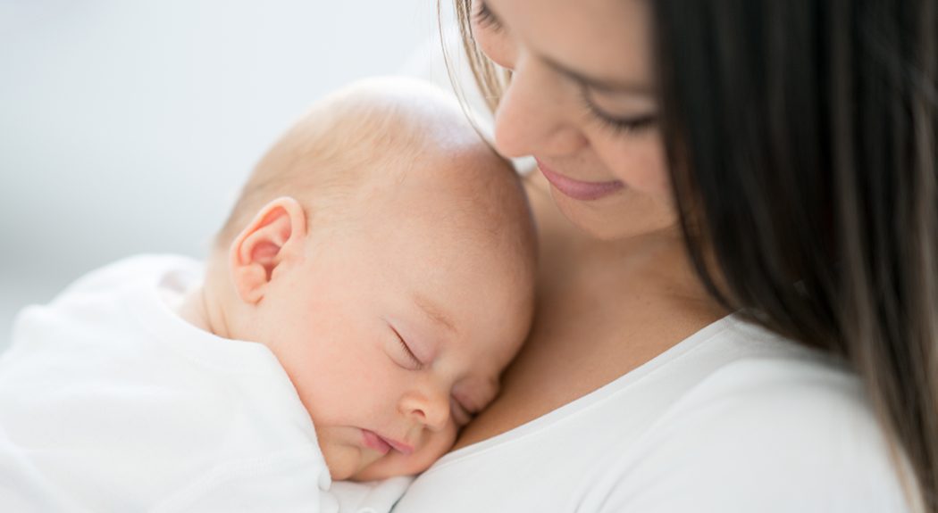 Mother holding sleeping newborn